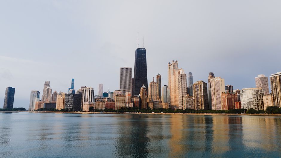 Stunning view of Chicago's skyline with calm waterfront reflections under a clear sky.